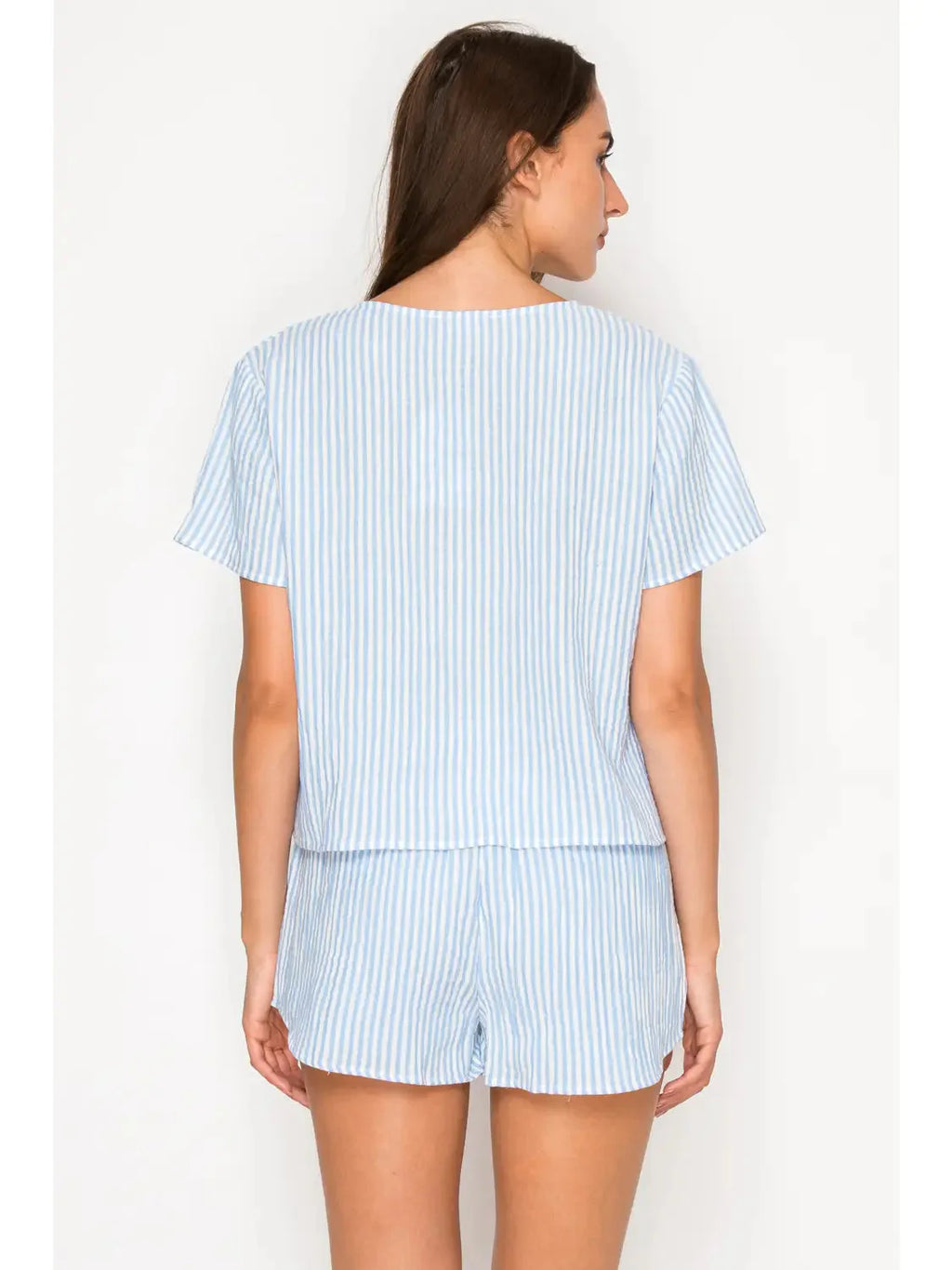 Woman wearing a light blue striped outfit on a white background