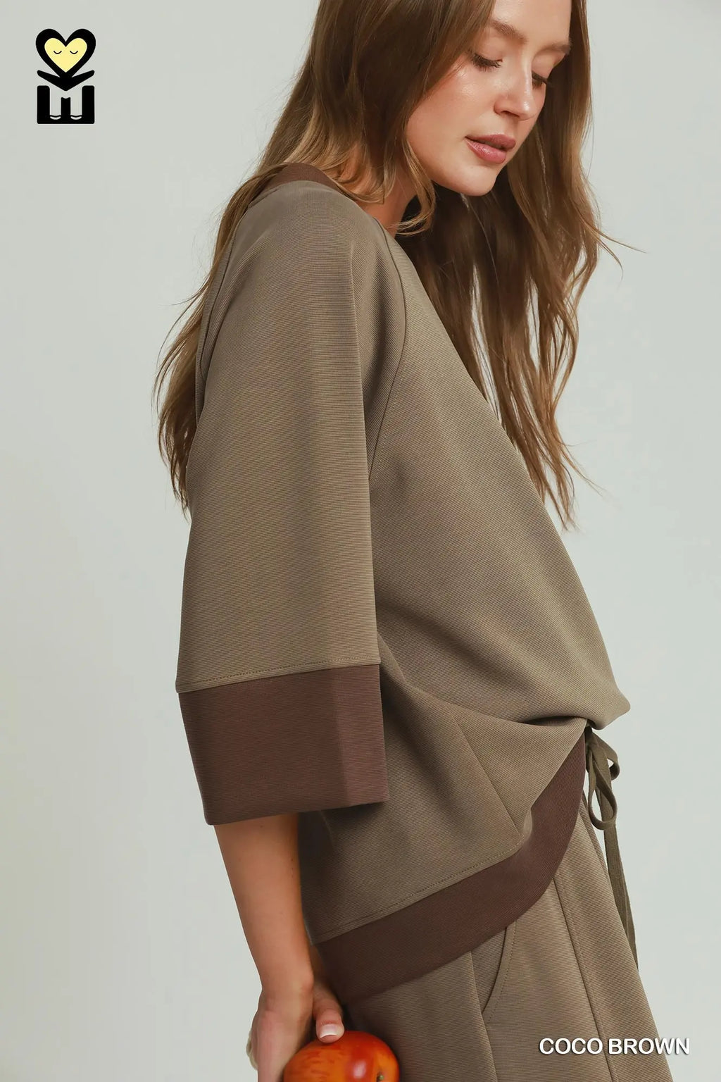 Person wearing a brown outfit with a plain background