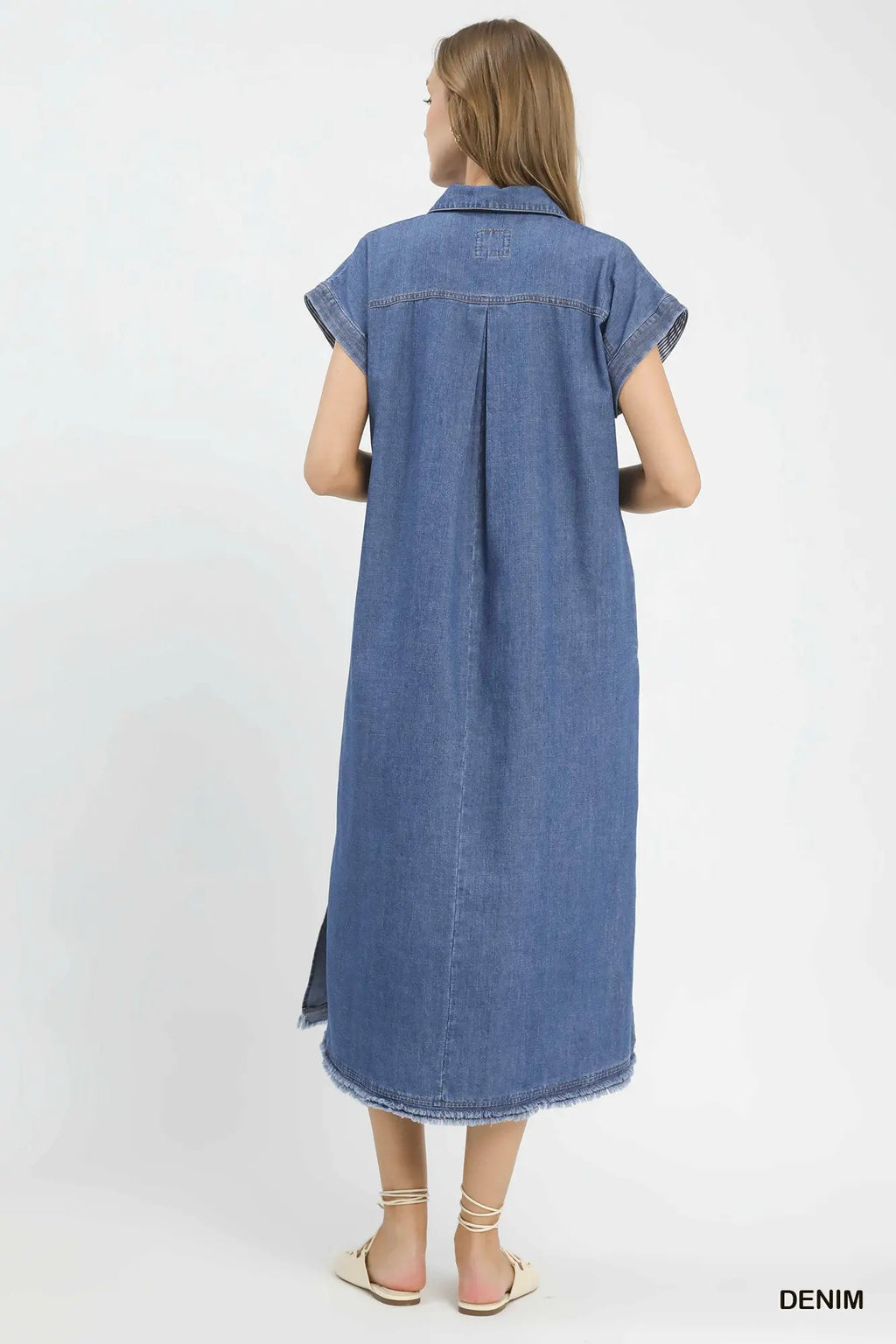 Woman wearing a long denim dress on a white background