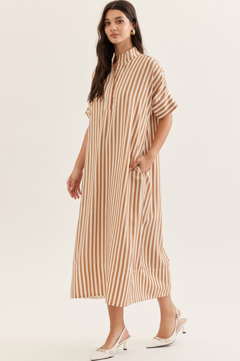 Woman wearing a beige and brown striped dress on a white background