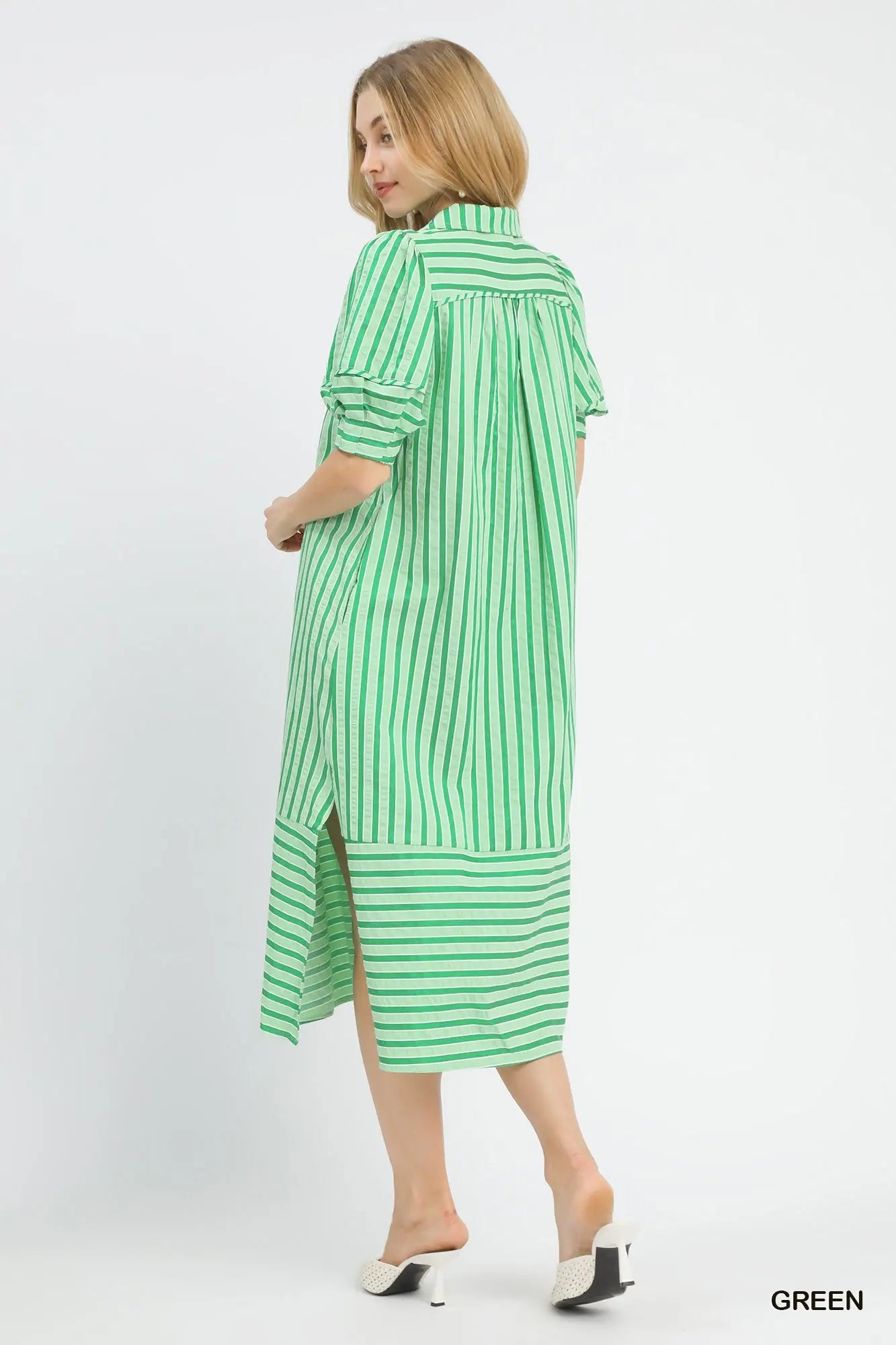 Woman wearing a green and white striped dress on a white background