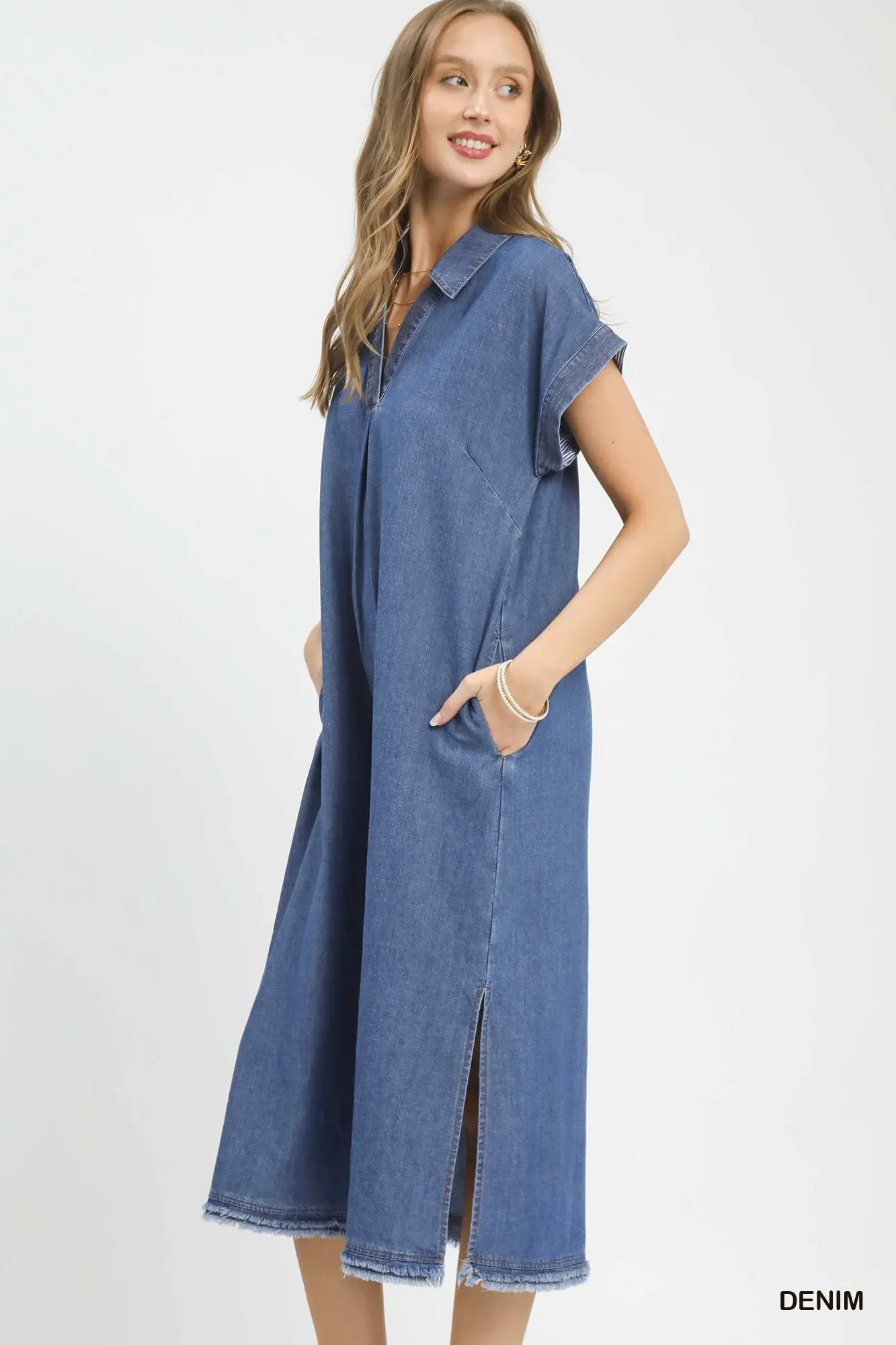 Woman wearing a long denim dress on a white background