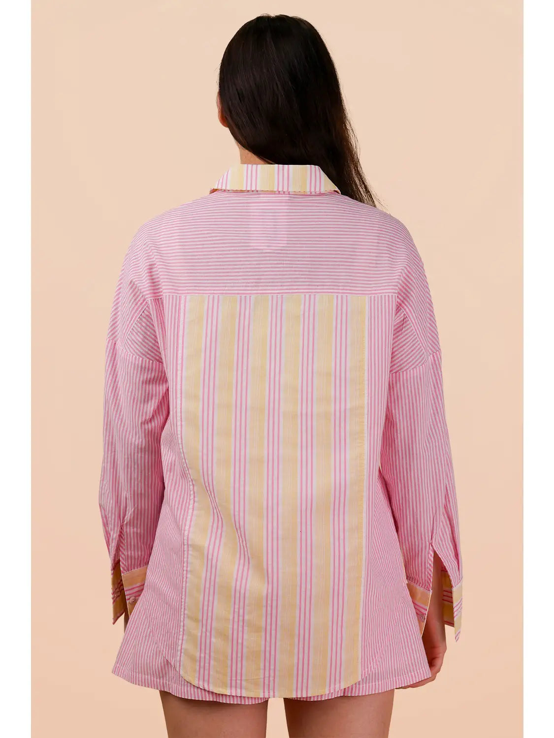 Woman wearing a pink and yellow striped shirt on a beige background