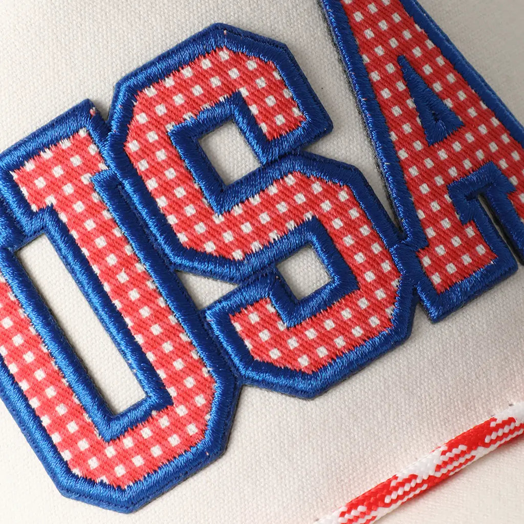 Embroidered patch with 'USA' in red and blue on a white background