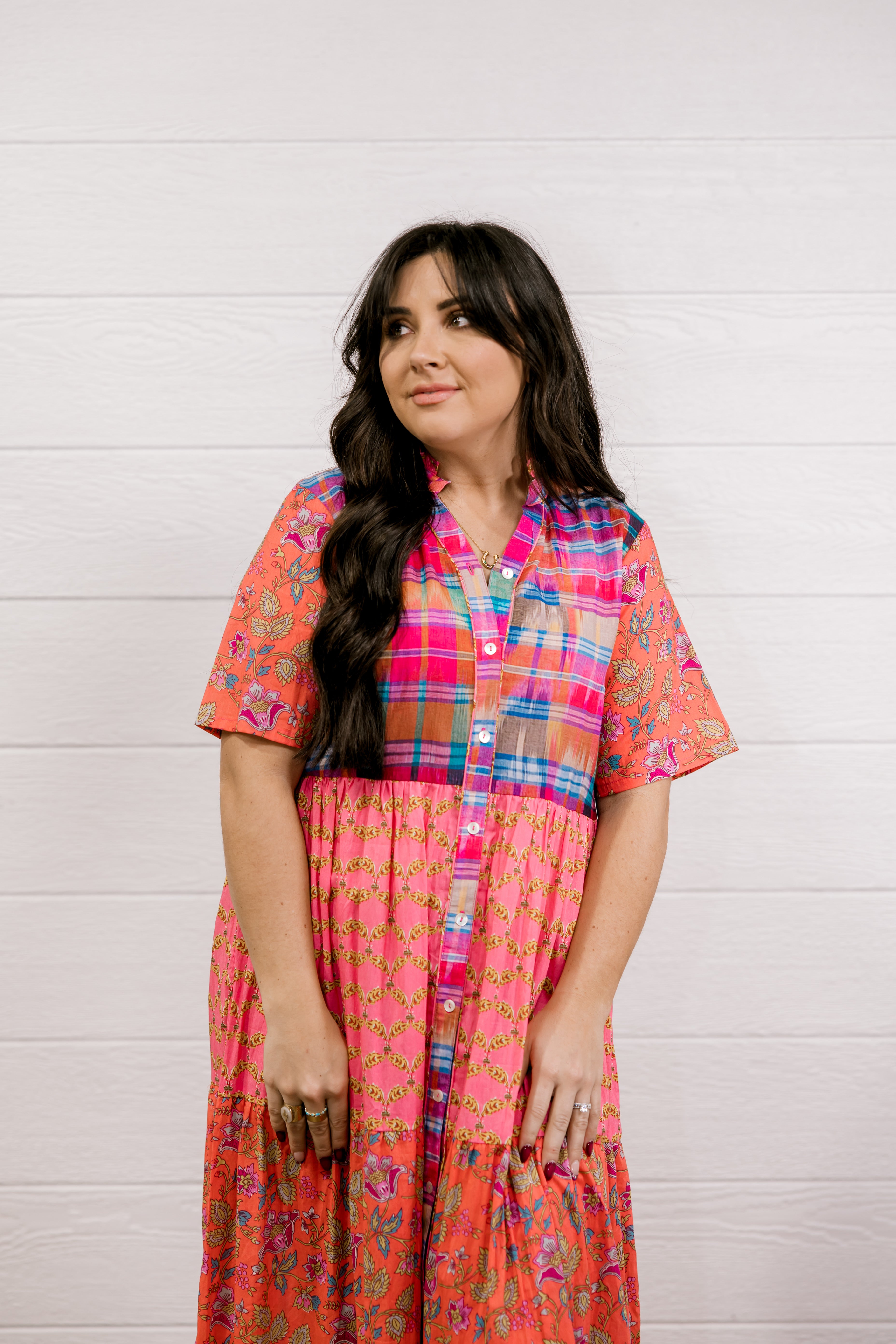 Woman wearing a colorful patterned dress against a white background