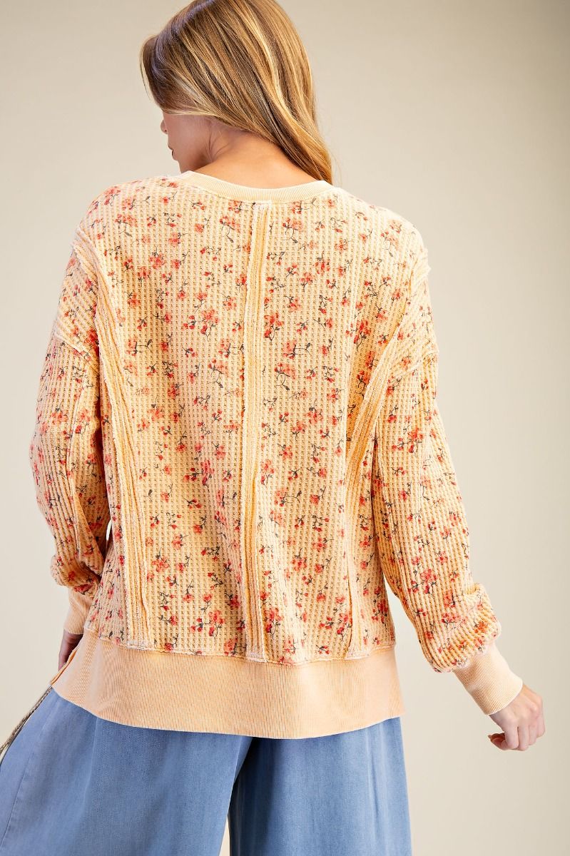 Woman wearing a floral blouse with a neutral background