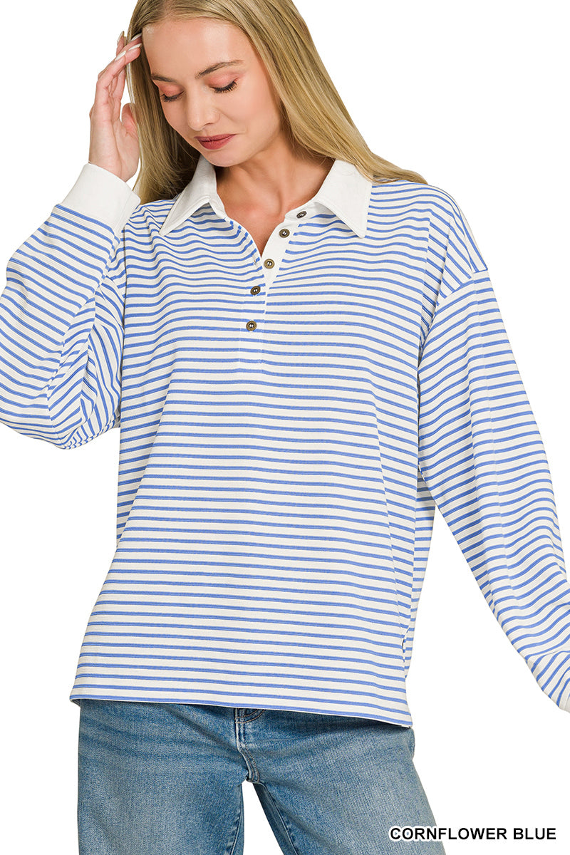 A woman wearing a long-sleeve collared knit top with horizontal blue and white stripes, paired with blue jeans, against a plain white background.