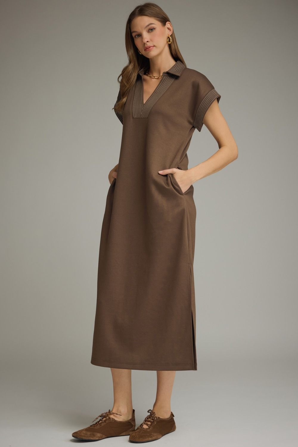 Woman wearing a brown dress against a neutral background