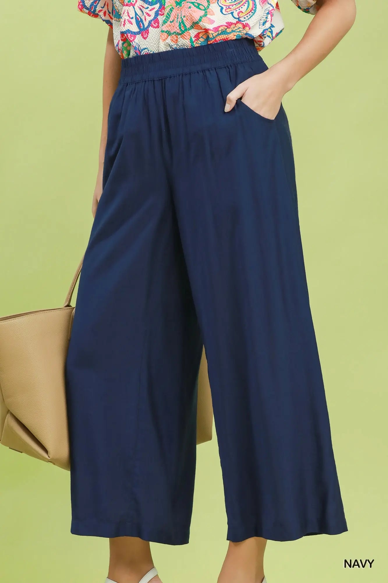 Navy wide-leg pants worn by a person on a green background