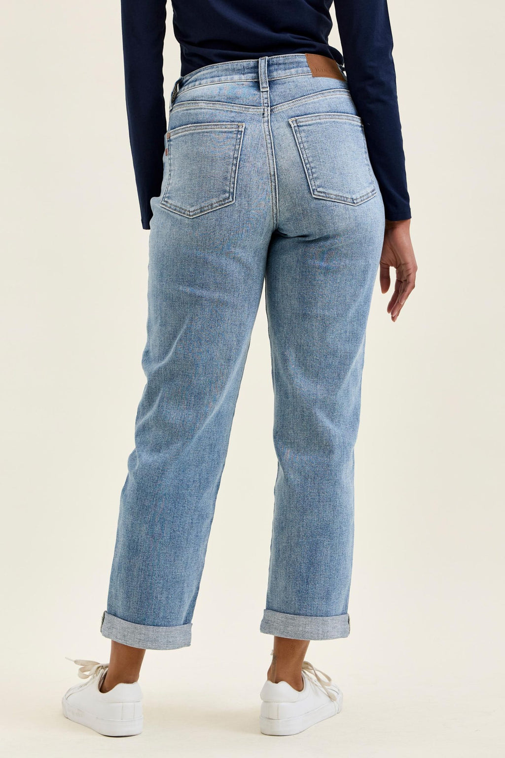 Person wearing light blue jeans with a plain background