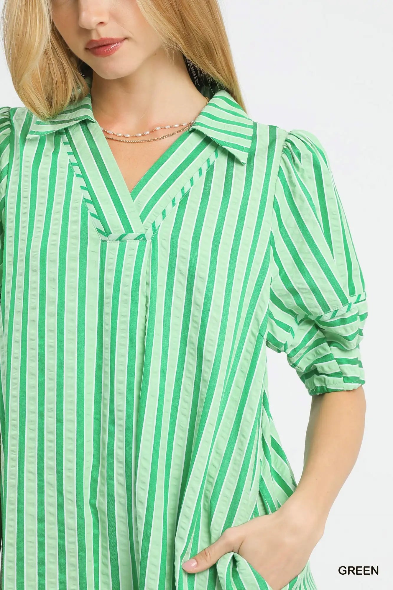 Woman wearing a green and white striped shirt on a white background