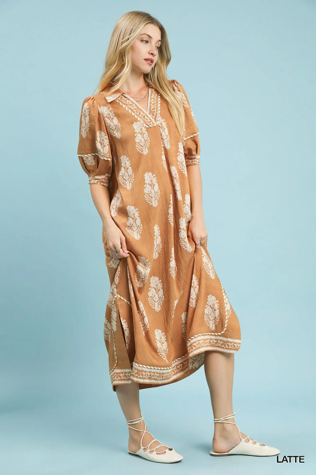 Woman wearing a patterned dress on a light blue background