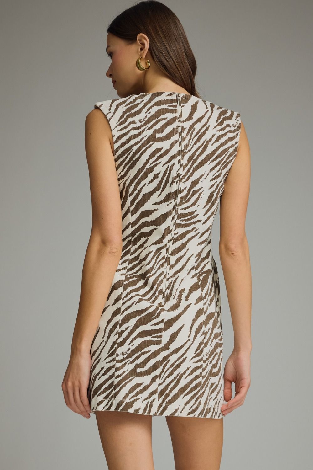 Woman wearing a zebra print dress against a gray background