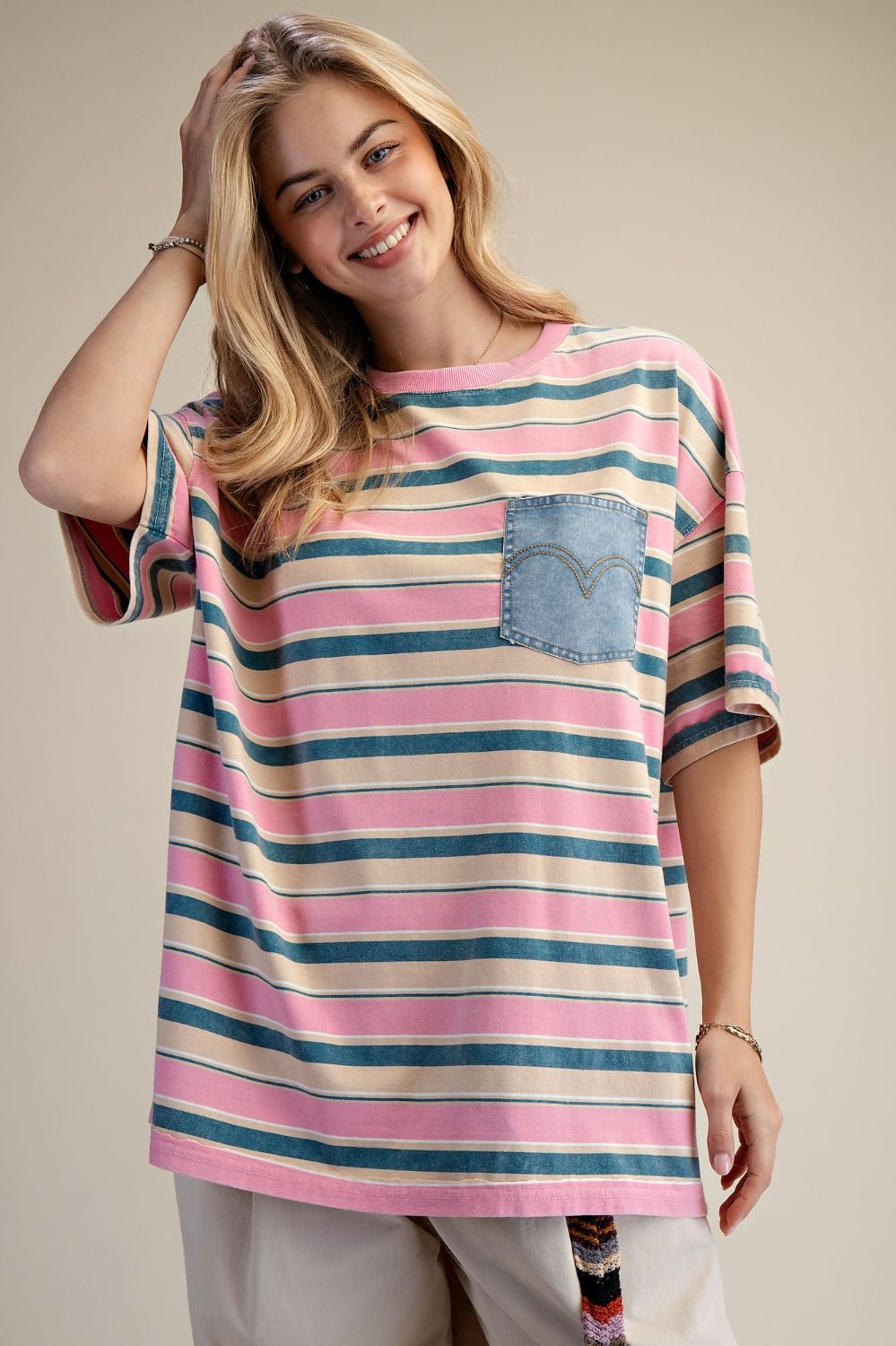 Woman wearing a striped t-shirt with a pocket on a beige background