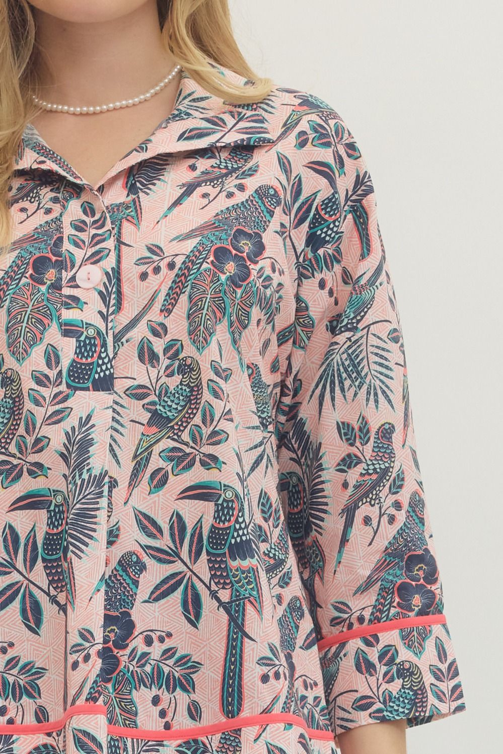 Floral patterned shirt with parrot design on a light pink background