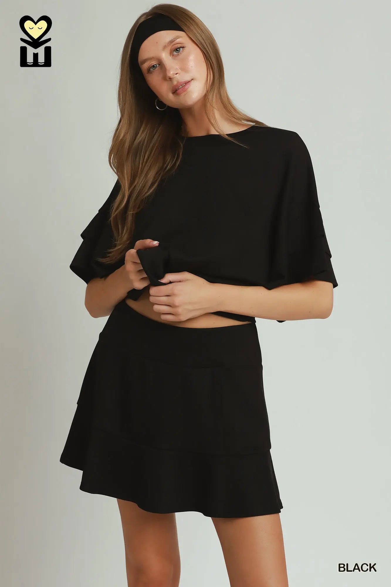 Woman wearing a black outfit with a plain background