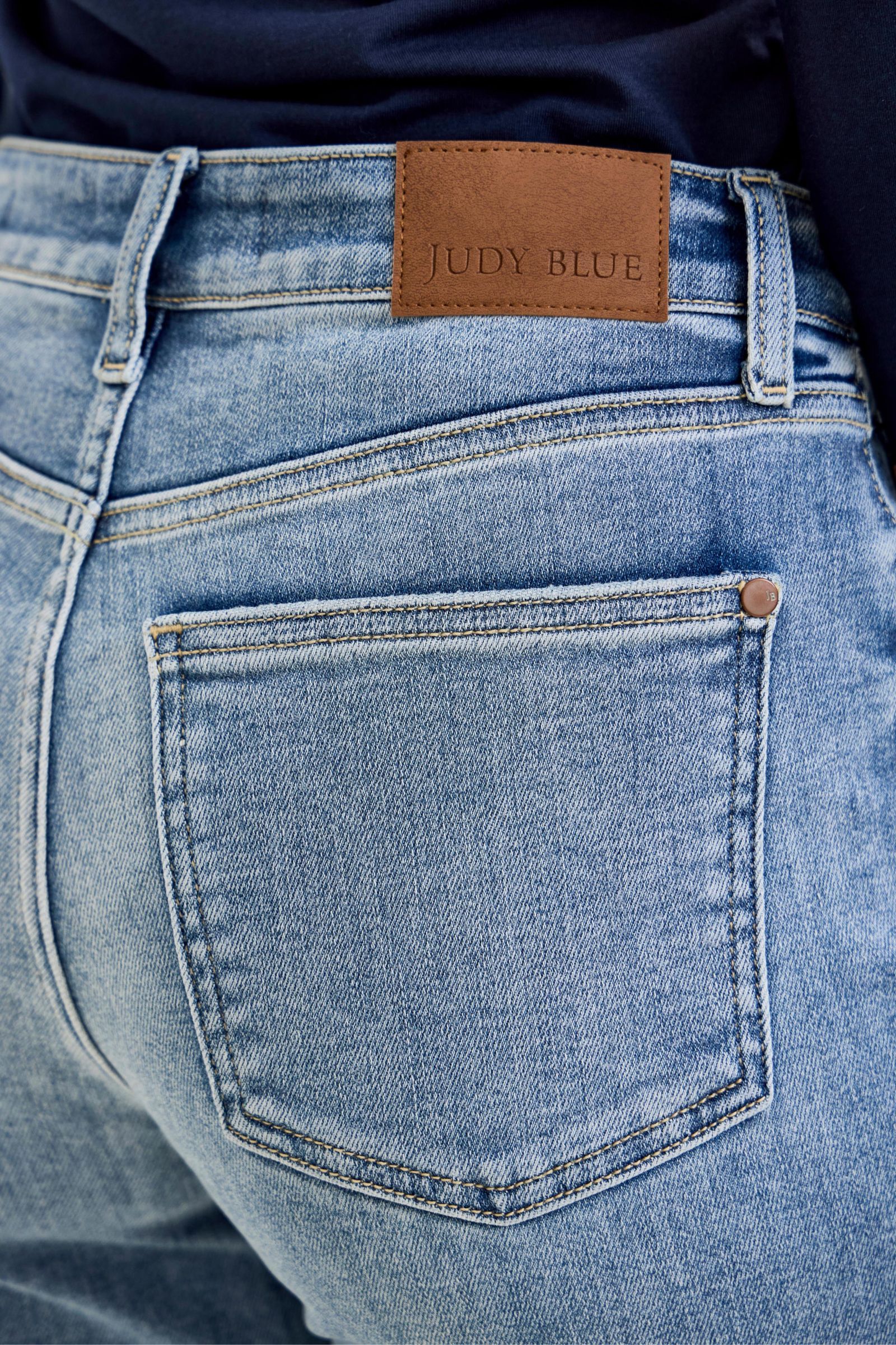 Close-up of blue jeans with a brand label on the pocket.