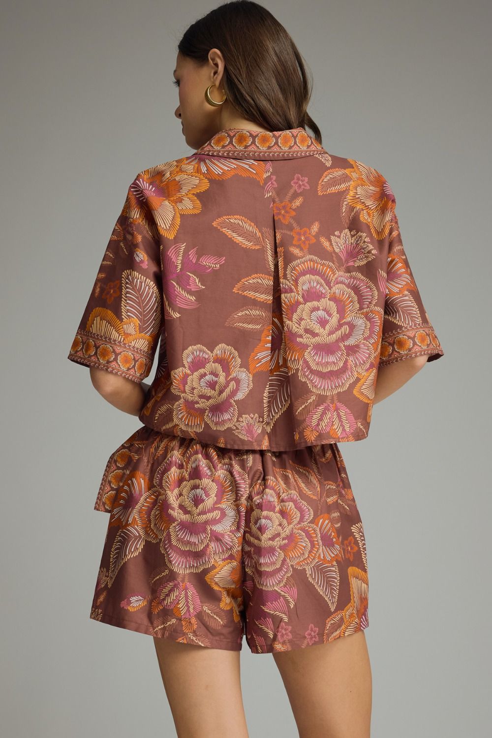 Woman wearing a patterned outfit on a gray background