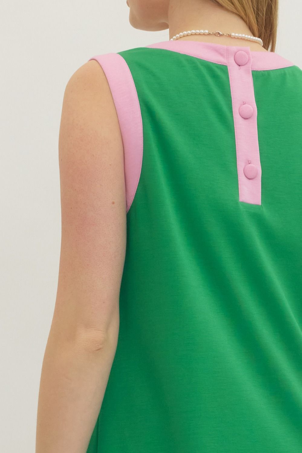 Green sleeveless top with pink accents on a plain background
