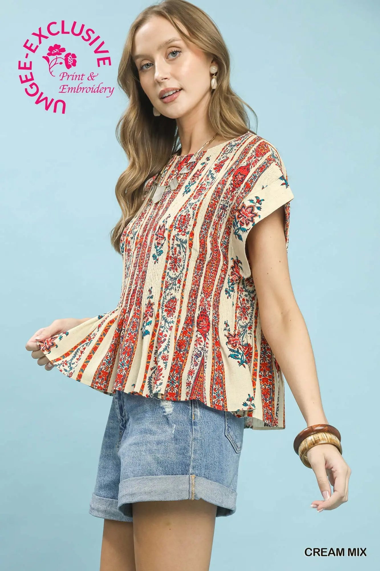 Woman wearing a patterned blouse and denim shorts on a light blue background with 'Ngee Anng' branding.
