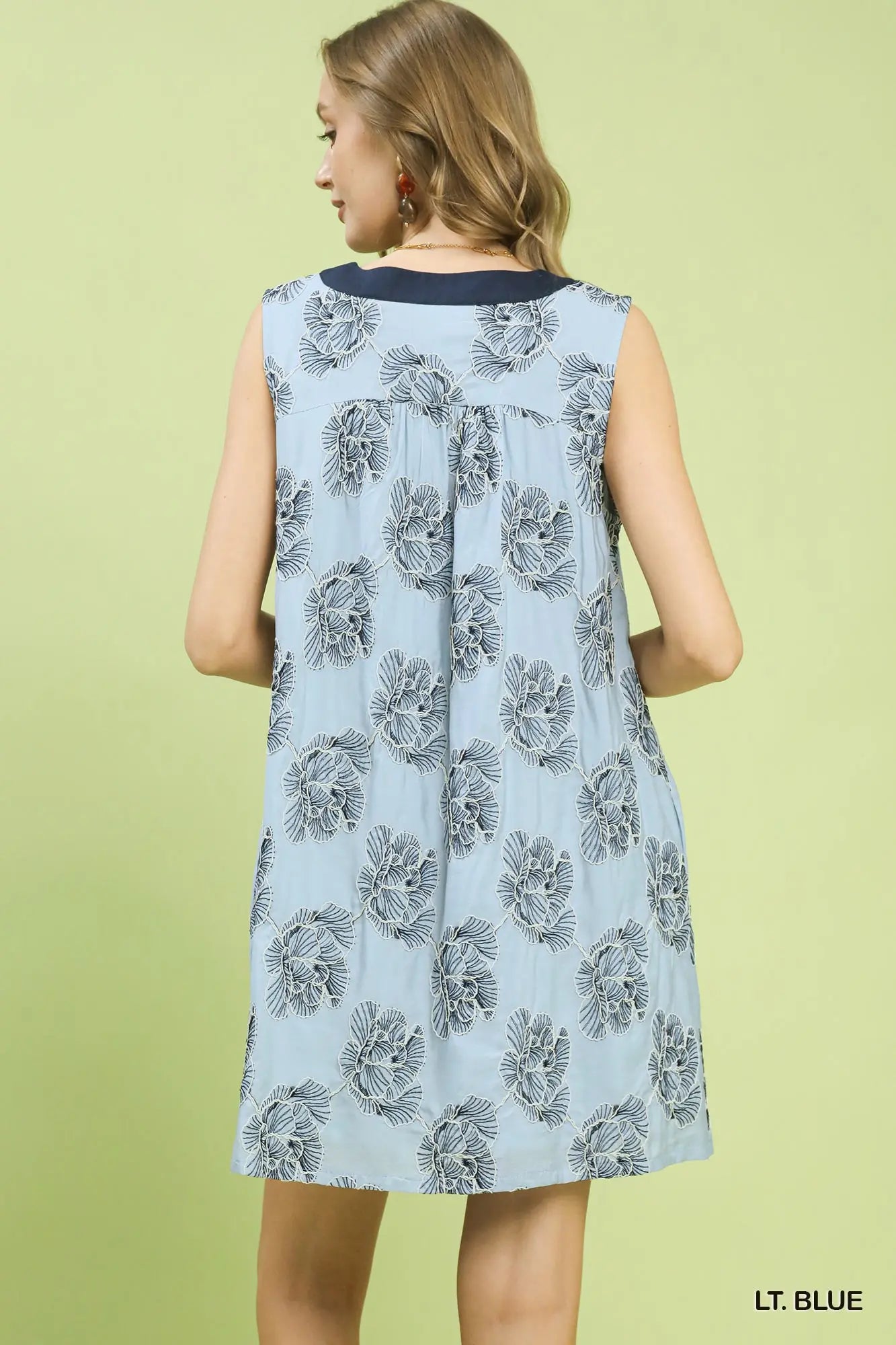 Light blue dress with black floral pattern on a green background