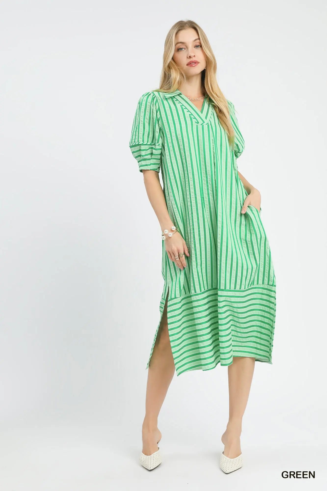 Woman wearing a green and white striped dress on a white background
