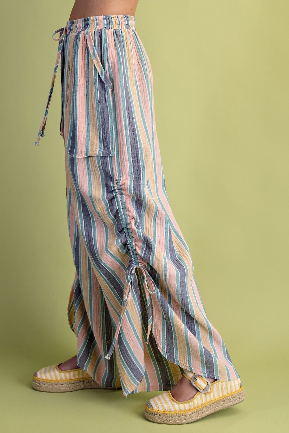 Multicolored striped pants worn by a person on a green background