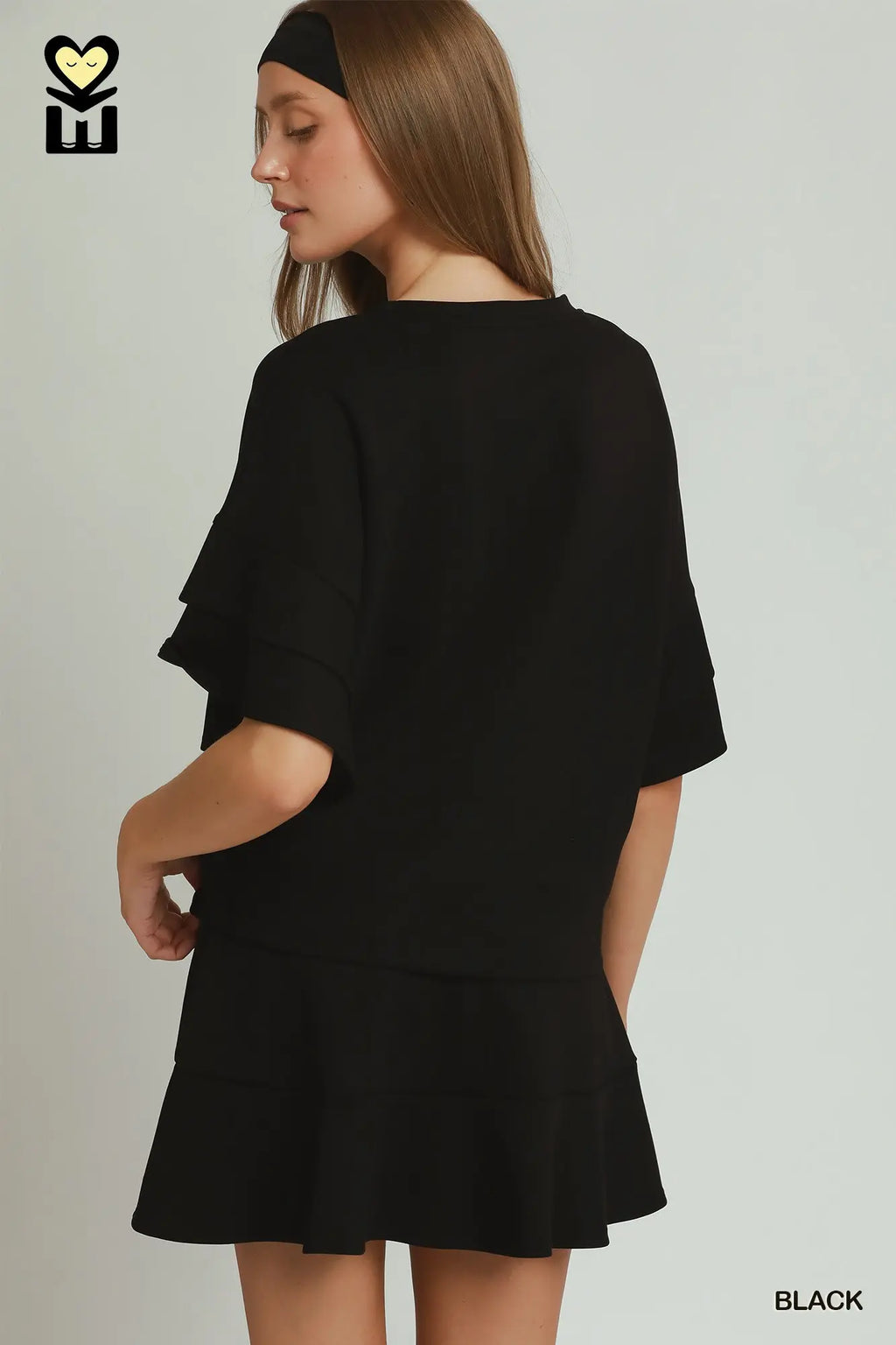 Woman wearing a black outfit with a plain background