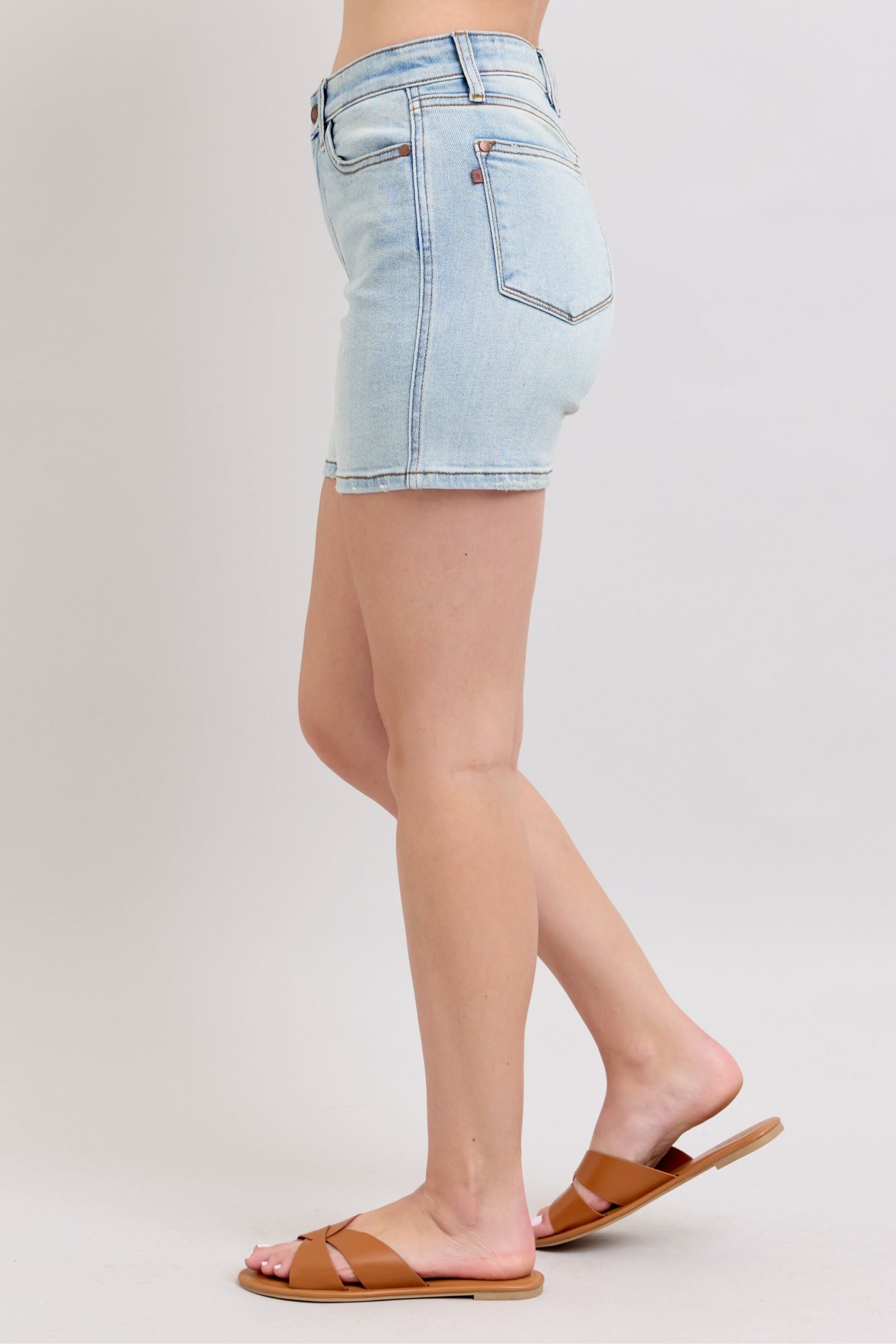 Light blue denim shorts worn by a person on a plain background