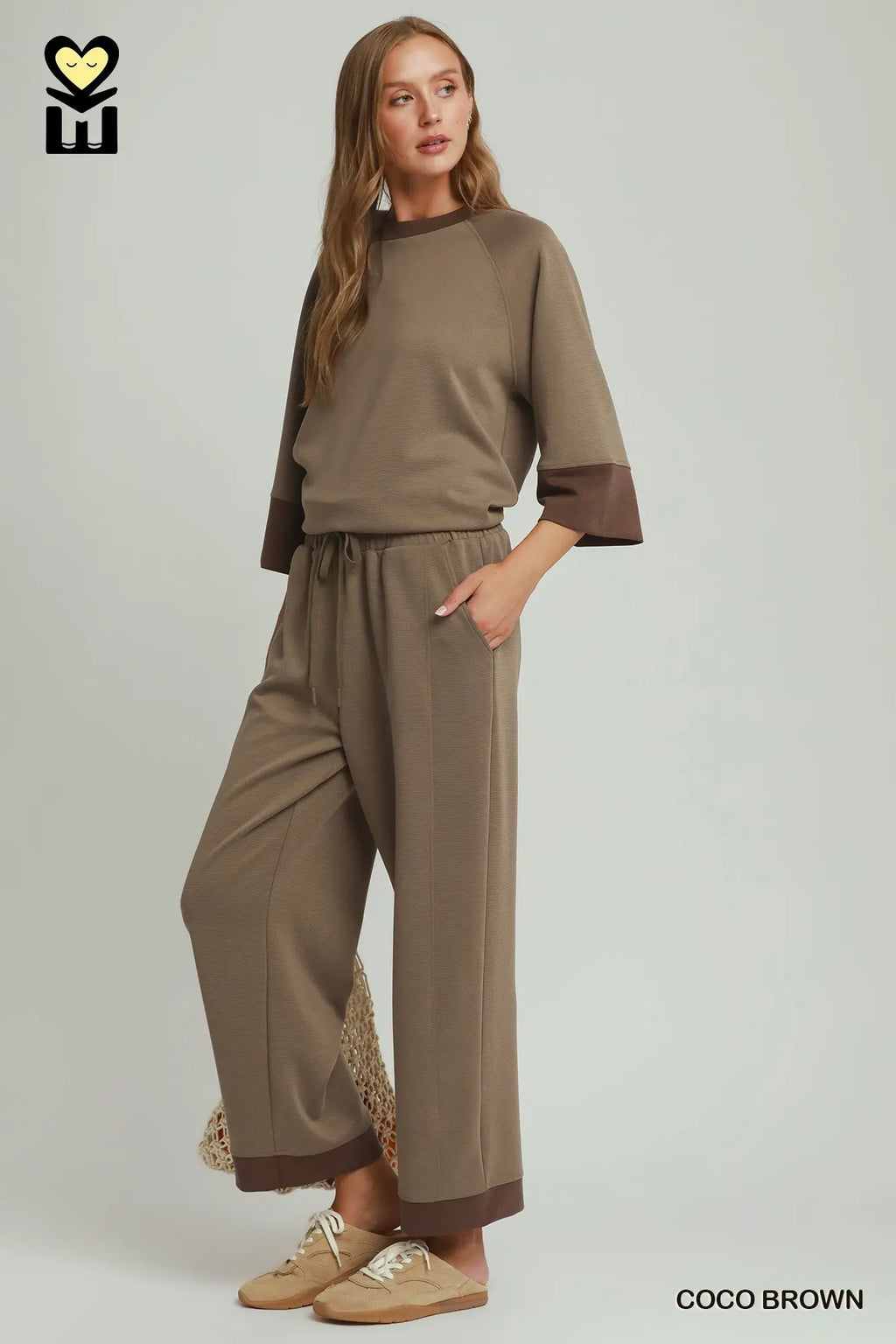 Woman wearing a brown outfit with a plain background