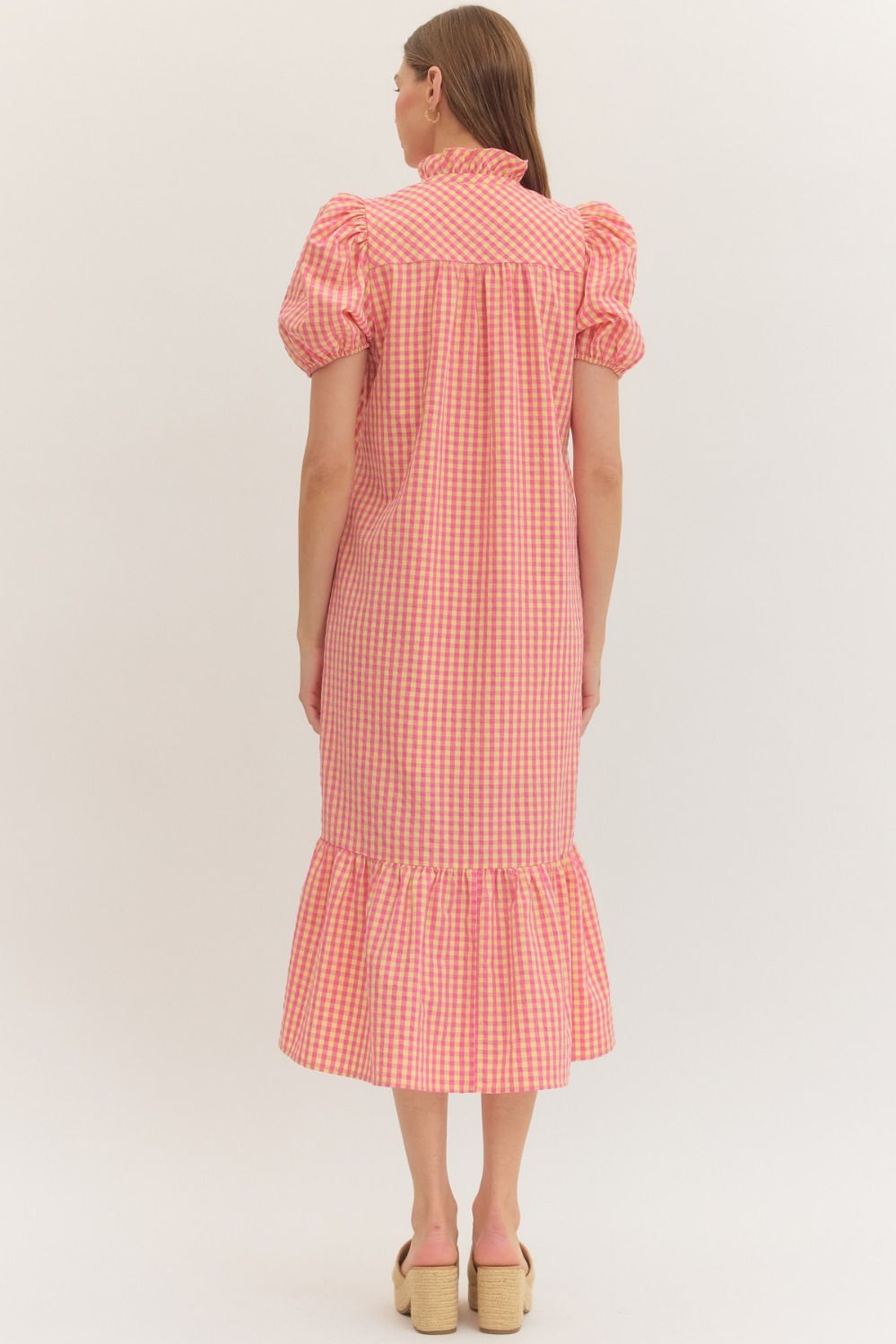 Woman wearing a red and white checkered dress on a white background