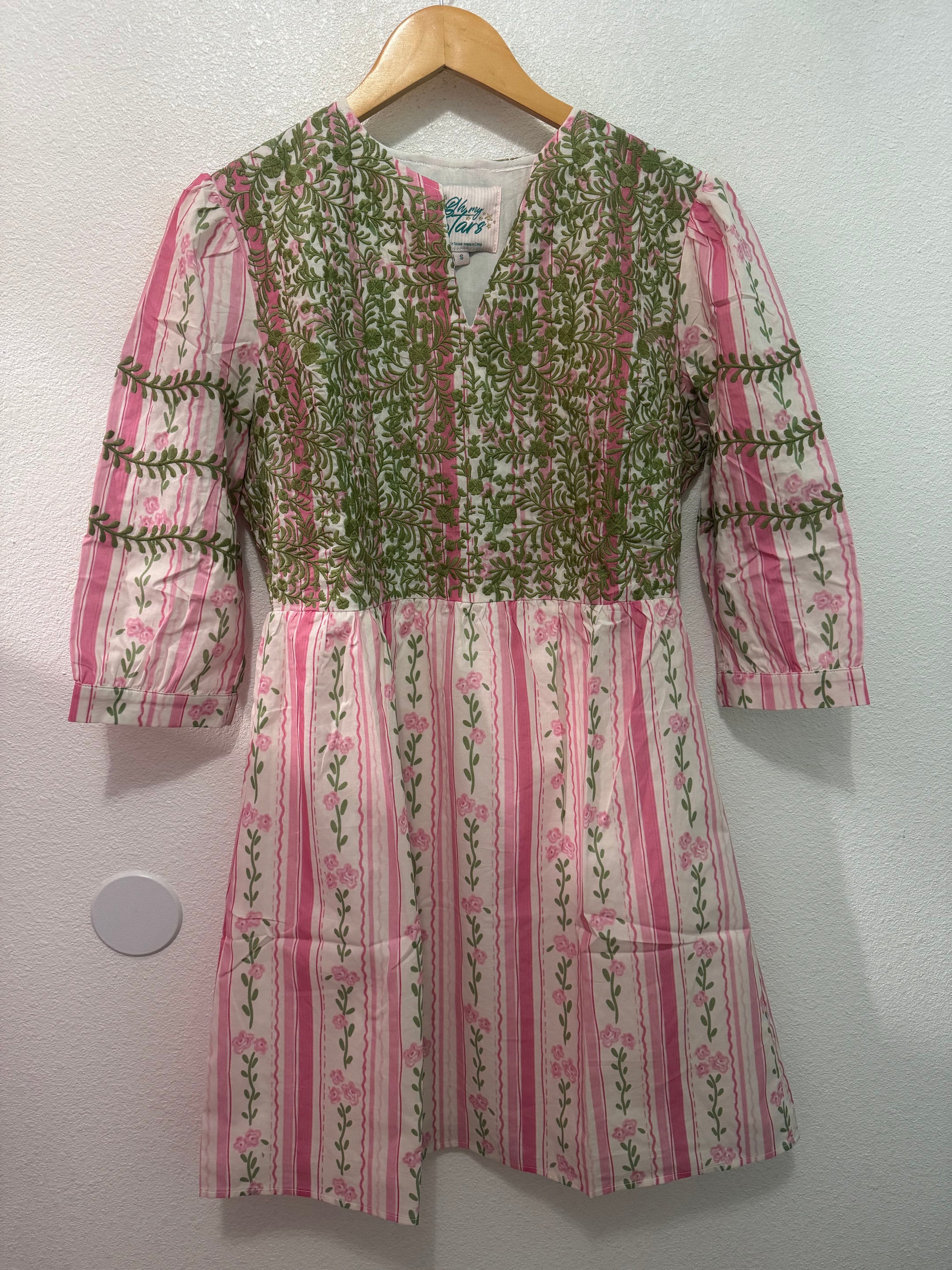 Floral-patterned shirt on a hanger against a white background