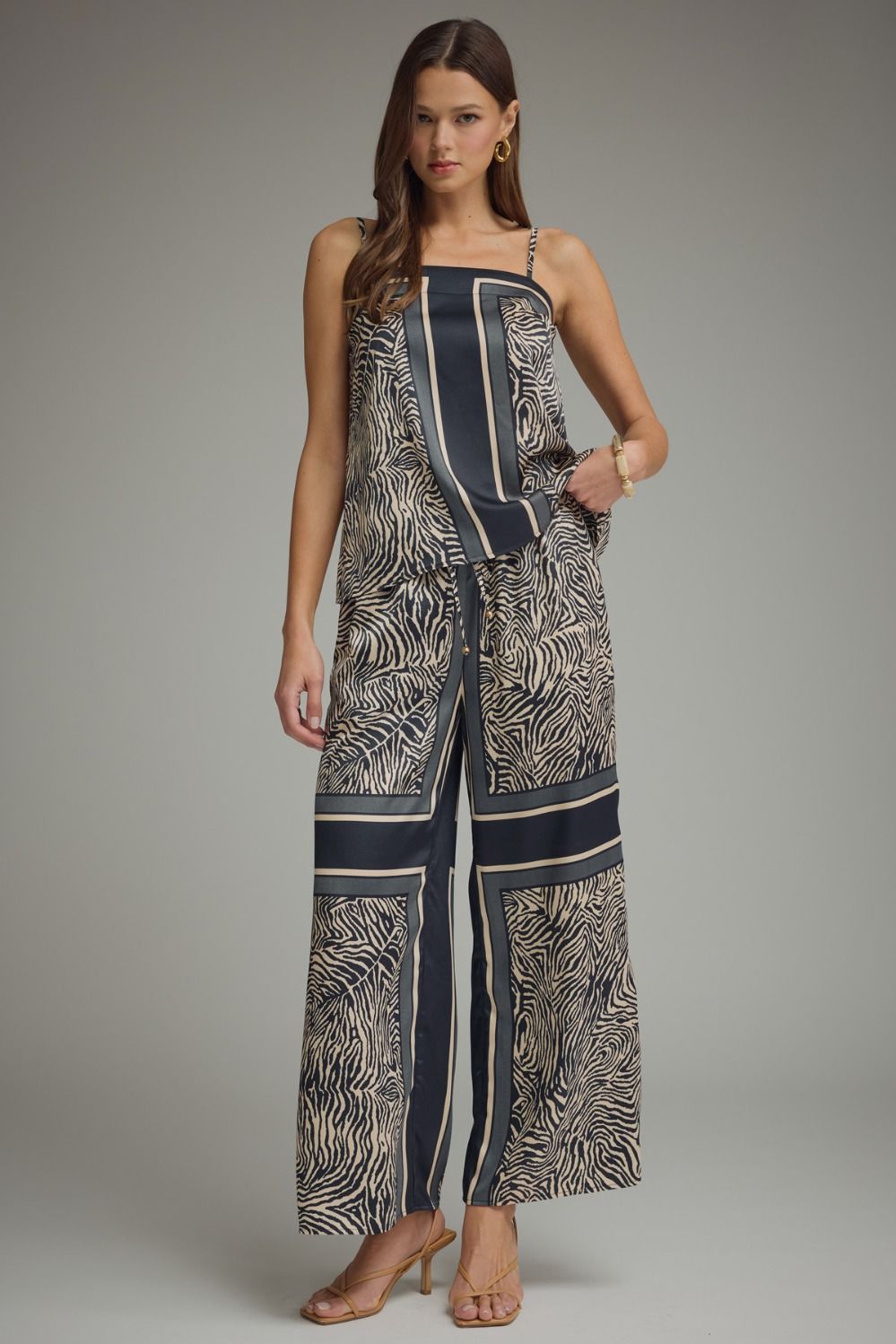Woman wearing a patterned jumpsuit on a plain background