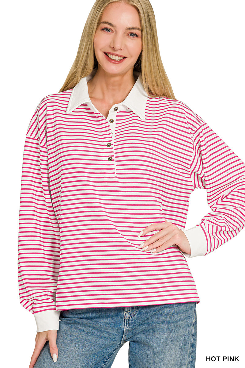 A woman modeling a long-sleeve collared polo shirt with horizontal pink and white stripes, paired with blue jeans against a plain white background.