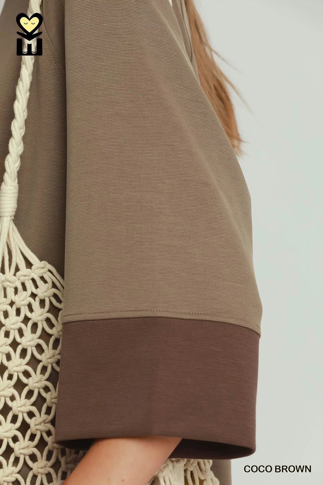 Brown garment with a white background and a visible brand logo.