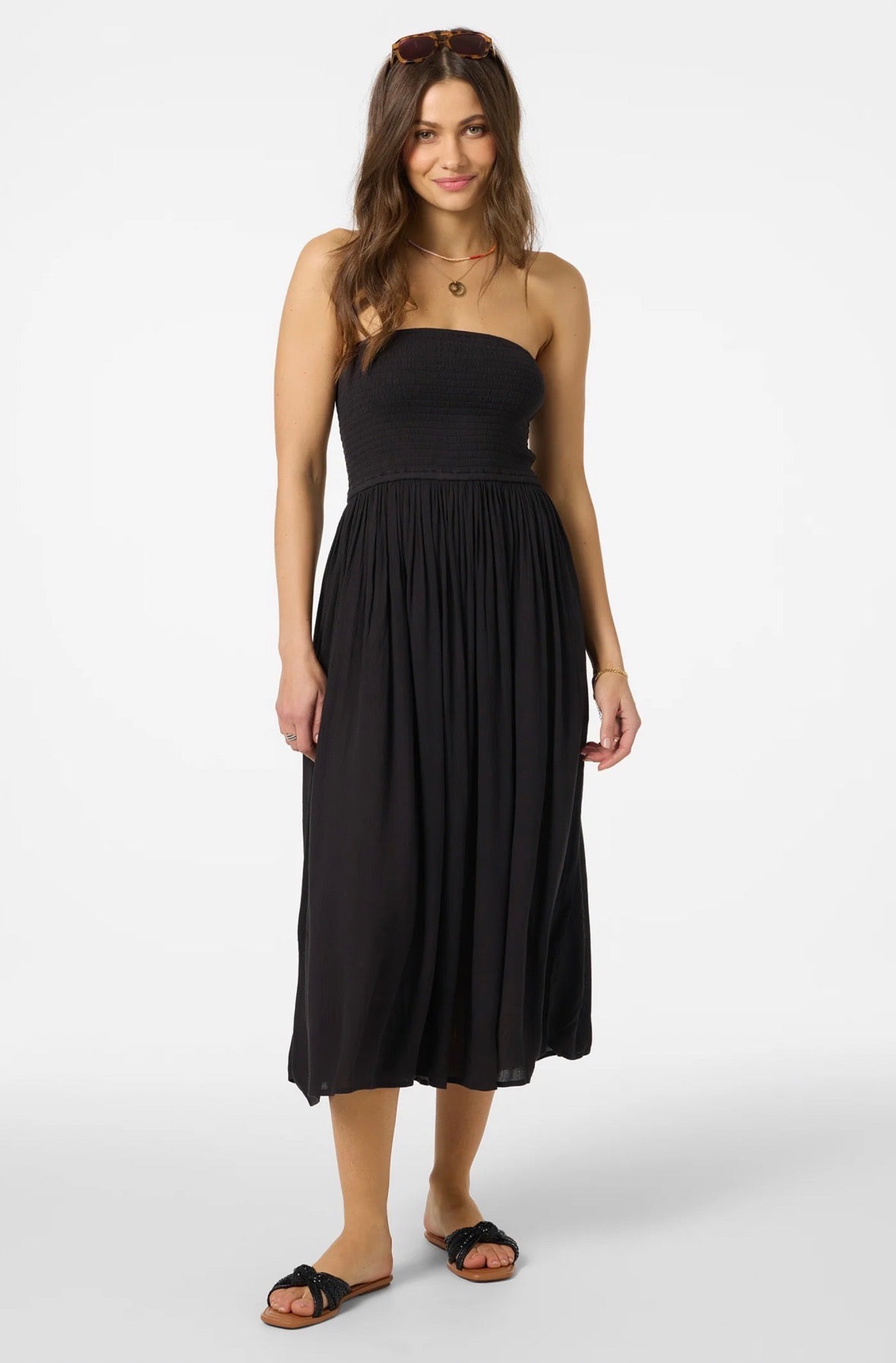 Woman wearing a black strapless dress on a white background