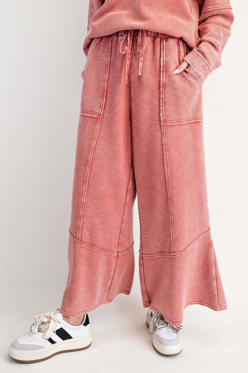 Person wearing red sweatpants and a matching top on a white background