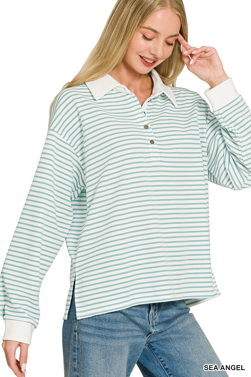 A woman wearing a long-sleeve collared polo shirt with thin mint green and white horizontal stripes, paired with blue jeans, against a plain white background.