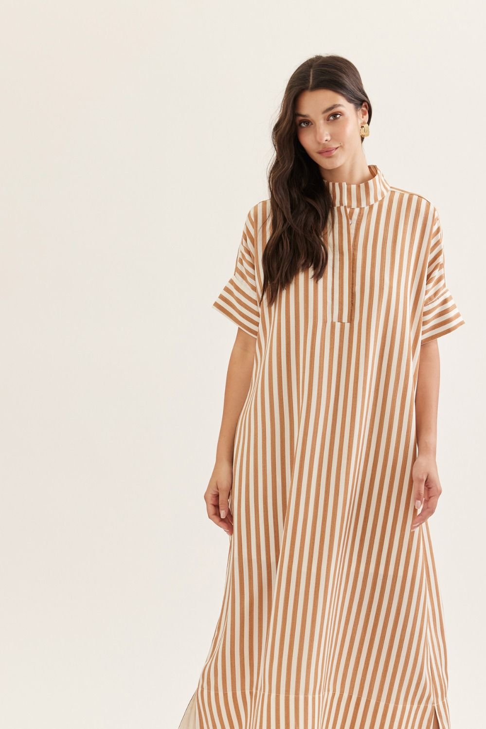 Woman wearing a brown and white striped dress on a white background