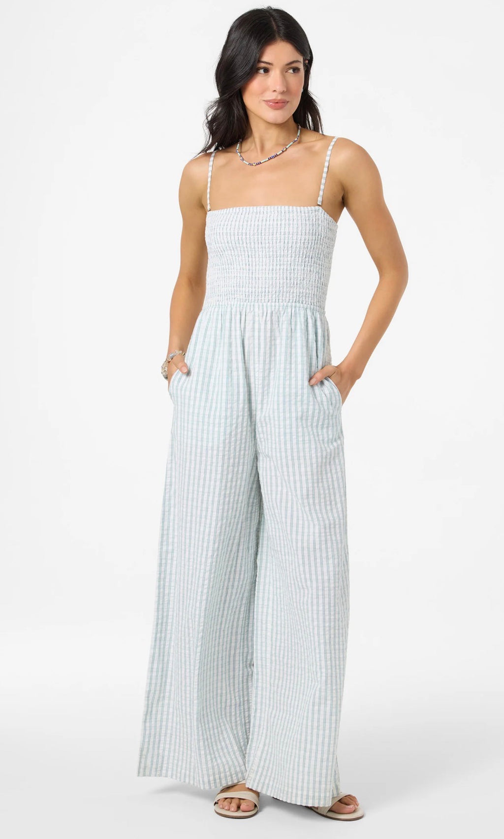Woman wearing a light blue and white striped jumpsuit on a white background