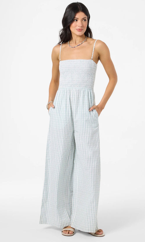 Woman wearing a light blue and white striped jumpsuit on a white background