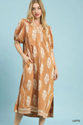 Woman wearing a brown dress with white floral patterns on a light blue background