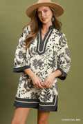 Woman wearing a floral dress with a hat against a green background