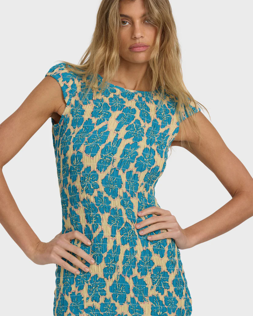 Woman wearing a blue floral dress on a plain background