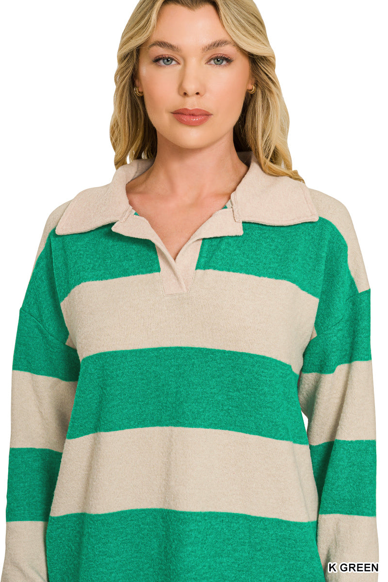 A woman wearing a long-sleeve knit polo-style top with wide horizontal stripes in green and cream. The image is cropped from the shoulders to below the hips on a plain white studio background.