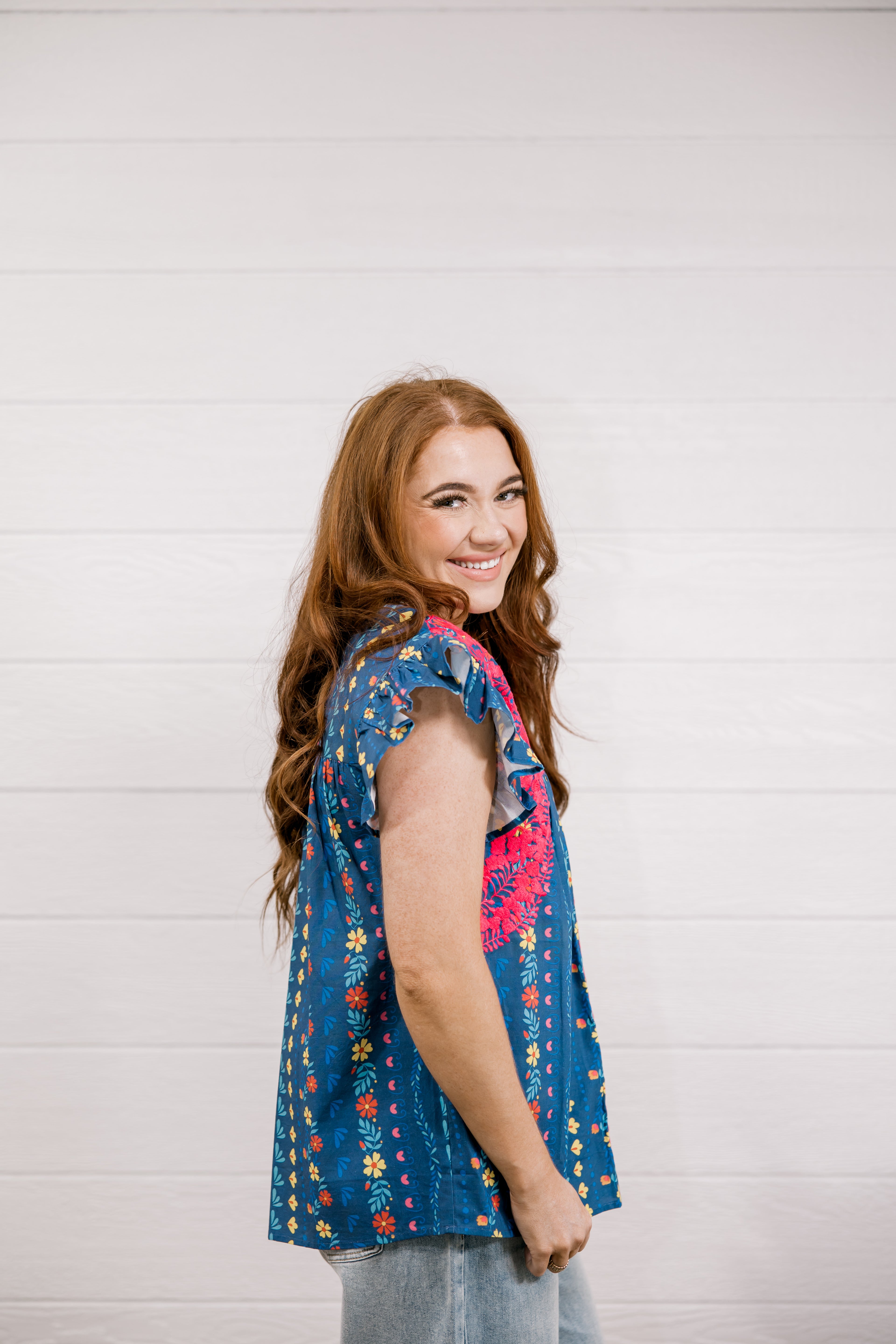 Woman wearing a blue floral blouse against a white background