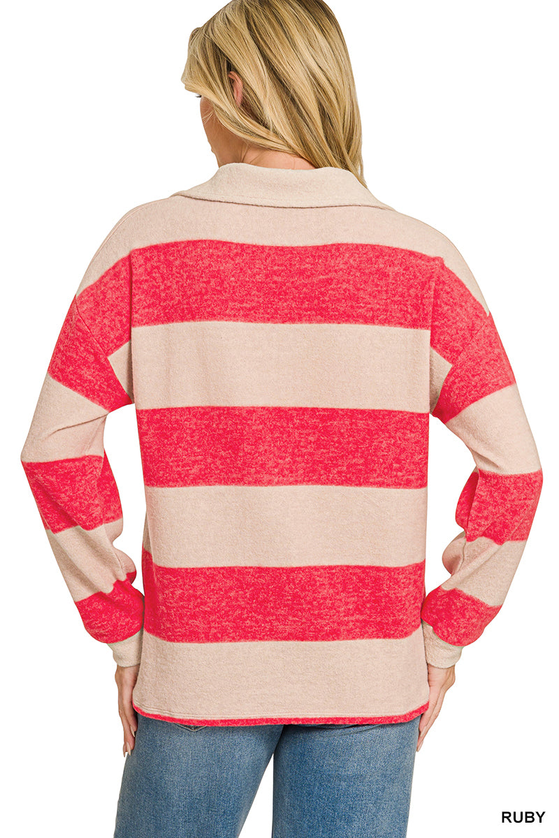 A woman shown from the back wearing a long-sleeve collared sweater with bold horizontal red and beige stripes, paired with blue jeans against a plain white background.