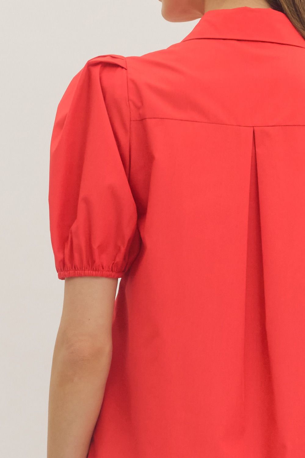 Red blouse with puff sleeves on a plain background