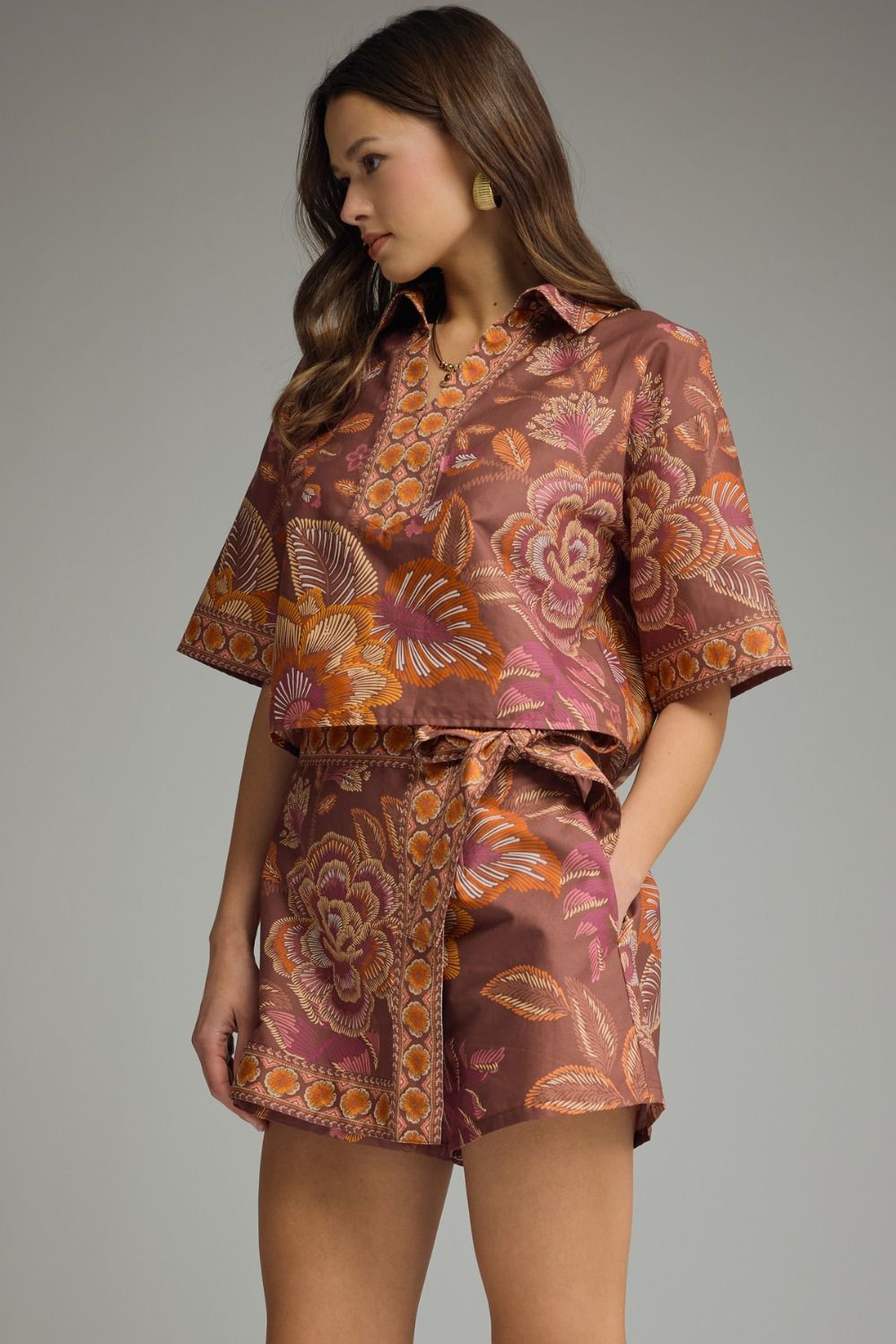 Woman wearing a patterned outfit with a top and shorts.