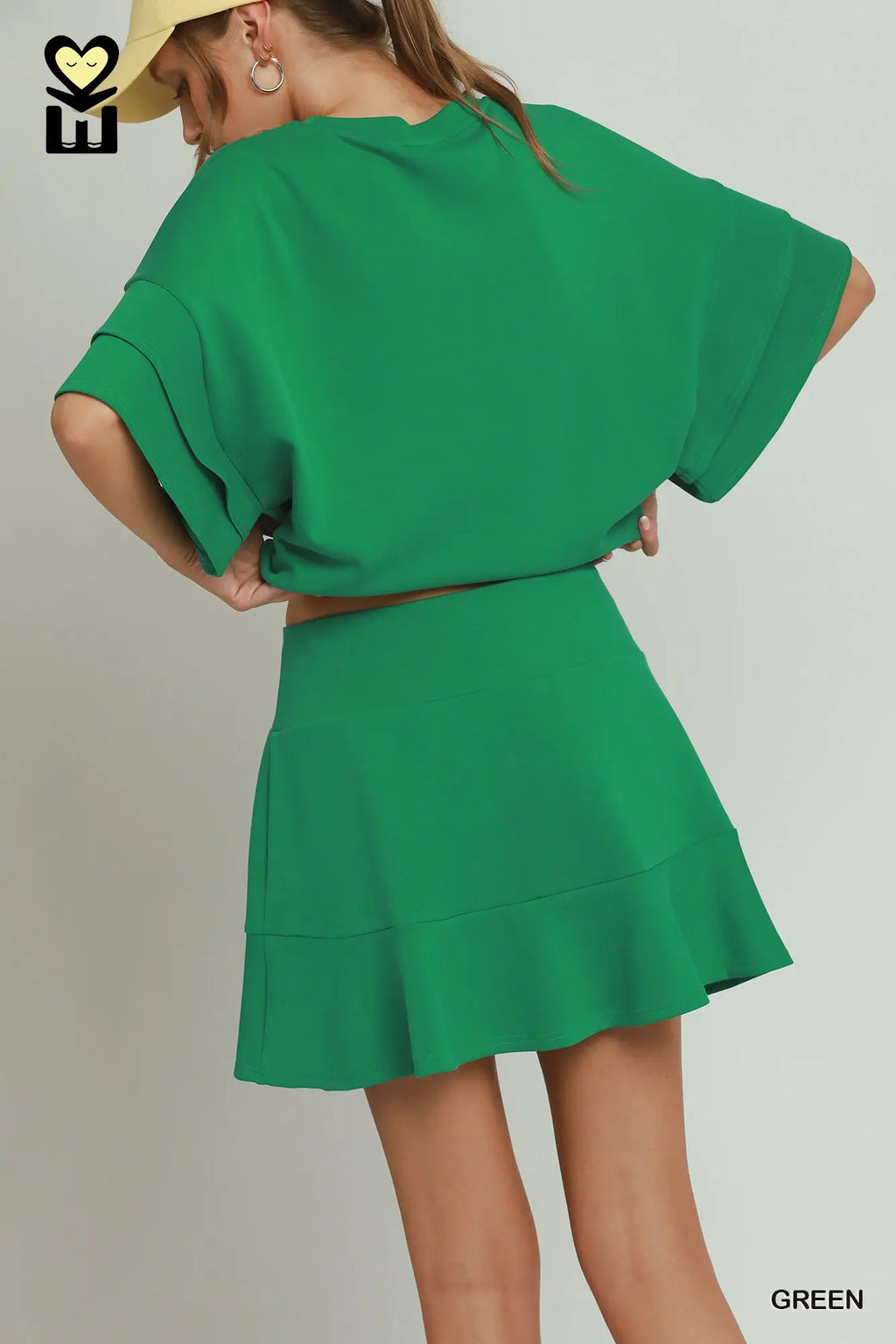 Person wearing a green outfit with a plain background